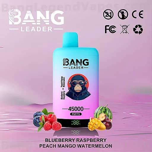 A gradient blue vape bottle labeled 'BANG LEADER' with a monkey wearing sunglasses on the label sits on a pink reflective surface, surrounded by blueberries, raspberries, mango and watermelon, with flavor text reading Blueberry Raspberry Peach Mango Watermelon and a display showing 45000 Puffs.